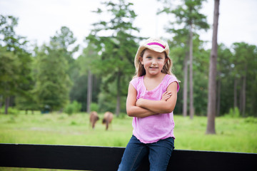 Little Girl on a Fence at a Horse Farm and Ranch