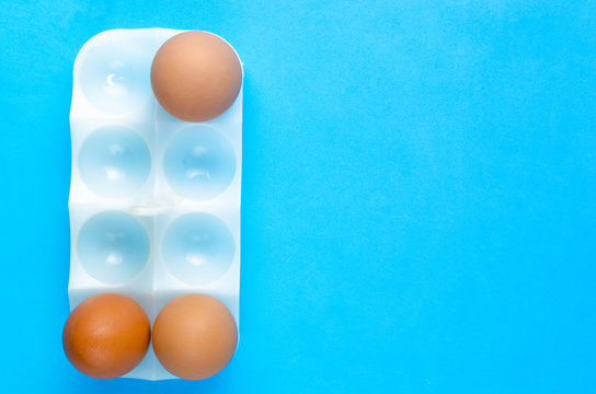 Three eggs in stand for egg on a blue background.