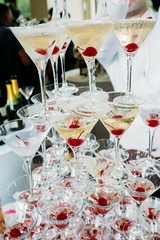 A glass of champagne with cherries, A pyramid of glasses with champagne, pyramid from glasses of champagne on wedding party, Catering bar for celebration