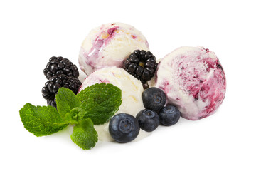 Three balls of ice cream with fresh blueberries, blackberries and mint