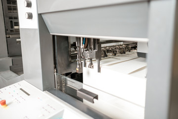 Paper supply part of the offset machine with a stack of paper at the printing manufacturing