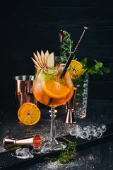 Foto op Plexiglas Alcoholic Cocktail Aperol at the bar. Orange. On a black wooden background. © Yaruniv-Studio