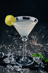 Alcohol cocktail Margarita. Tequila, lime, ice. On the black background bar.