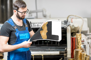 Worker checking the quality of the foil stamping at the manufacturing