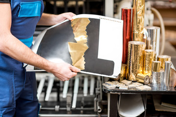 Worker checking the quality of the foil stamping at the manufacturing
