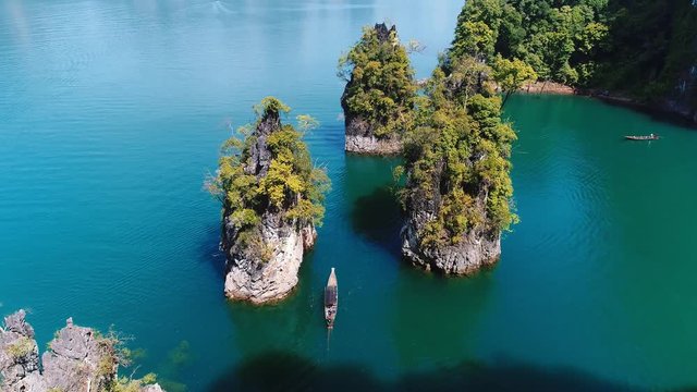 AERIAL. Traditional thai boat sail between of the three mountains rock in thailand national park.