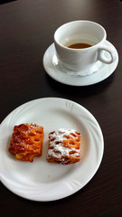 Coffee break.
White cup with a little coffee and a white plate with two cookies.