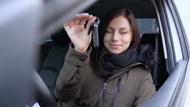 Young Woman Sitting in New Car Showing Car Keys