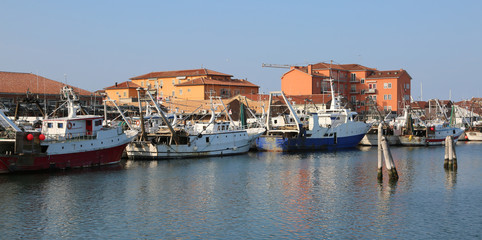 Fototapeta na wymiar Chioggia, VE, Italy - February 11, 2018: fishing boats moored in the industrial port on the Adriatic sea