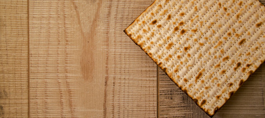 Handmade Matzot on weathered wooden background with copy-space.Flat lay