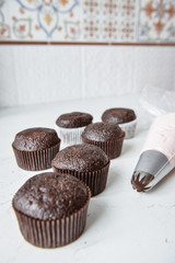 Tasty cupcakes on background table. Homemade chocolate muffin cupcake with cream buttercream icing. Birthday cupcake. Valentine cupcake sweets. Close up view delicious sweet dessert