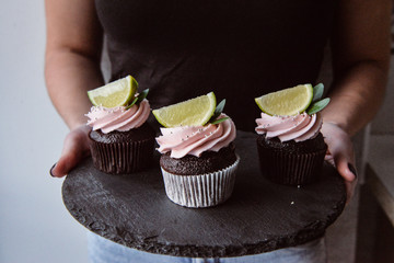 Tasty cupcakes on background table. Homemade chocolate muffin cupcake with cream buttercream icing....