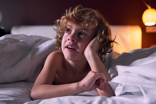 Happy boy lying in bed