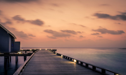 Obraz premium Wooden jetty and amazing sunrise in Maldives