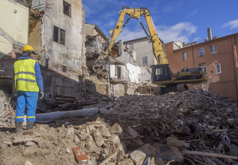 Fototapeta premium Workers tearing down building in an urban environment