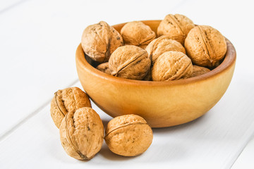 Shells and bones of walnut on a white wooden table.