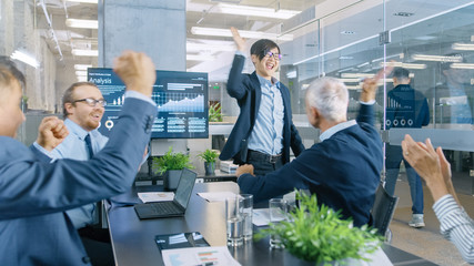 Asian Businessman Gives Report/ Presentation to Her Business Partners Everybody Cheer and Applaud and Give High Five Approving His Project.