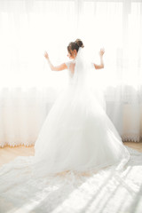 Luxury bride in white dress posing while preparing for the wedding ceremony