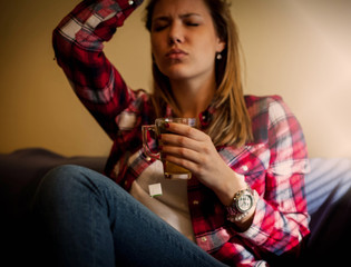 Woman With Cup Of Tea Having A Headache.