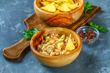 Guacomole is a traditional Mexican sauce consisting of grated avocado, lime juice, red onion, tomatoes, garlic and chili. Served with nachos chips.