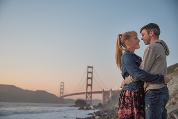 Loving couple embracing under Golden Gate Bridge