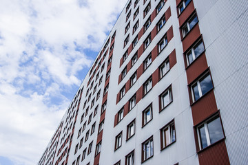 Block of flats high in the blue cloud sky.