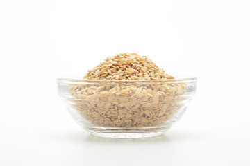 Lino dorado en un bol de cristal transparente sobre fondo blanco