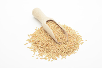 Lino dorado en una cuchara de madera sobre fondo blanco