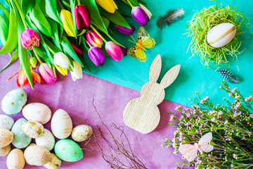 Freifläche auf Hase mit buntem Hintergrund und Tulpen im Frühling, Ostereier von oben zu Ostern