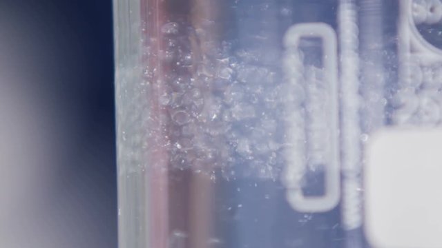 White Parts Turn Round in Clear Substance Macro