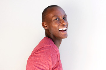 Close up handsome black man laughing against white background