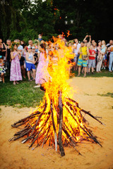 Naklejka premium Large Bonfire on the background of people. The celebration of Ivan Kupala