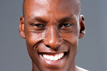 Close up smiling handsome black man against gray background
