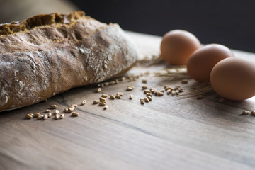 Freshly baked traditional bread with wheat and egg on wooden backround