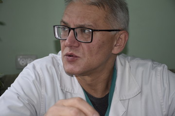 портрет пожилого врача смотрящего в сторону 