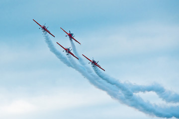 Formation of planes on the blue cloudy sky during the airshow.