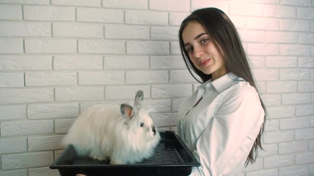 Girl with a white bunny. Rabbit on a baking sheet. Easter bunny.
