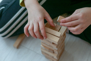 The child plays in a tower of wooden bars.