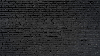 Fototapeta na wymiar Black wall as background, texture of a black brick wall