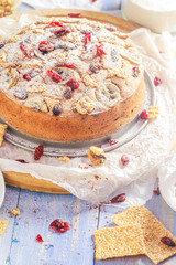 Delicious banana cake with nuts, sesame and cranberry on a wooden table
