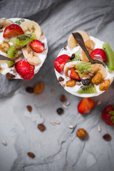 Obraz premium Nutrition Yoghurt fruit dessert strawberries banana kiwi raisins sunflower seeds oatmeal walnuts caramel