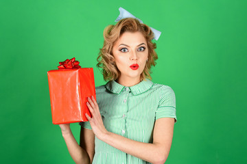 Sexy blond girl with retro makeup hold present box.