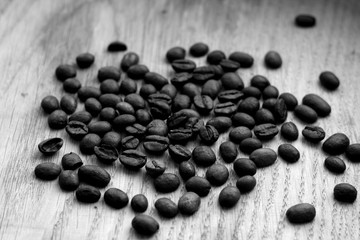 Coffee beans on wooden board with blur effect in black and white.