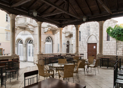 Old wooden and stone porch in a square of the ancient city of Rab on the Croatian island of the same name.