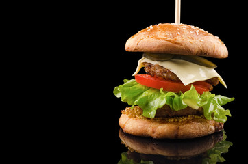 Big double cheeseburger isolated on black background