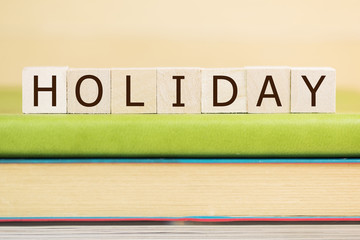 Holiday word built with letter cubes on green book 