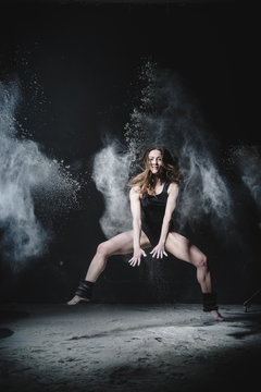 Girl dansing with flour on black background