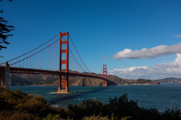 Fototapeta na wymiar Golden Gate bridge on a sunny day with a blue sky and white clouds, San Francisco, California