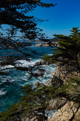 Dramatic landscape view of a waves crashing off shore acquamarine ocean, Big Sur Ocean Highway, California