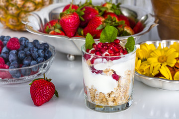 Breakfast with muesli, yogurt, fruits and edible flowers